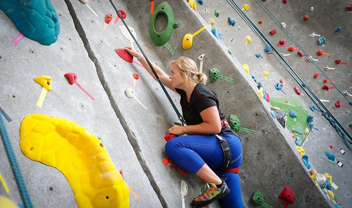 a student uses the climbing wall